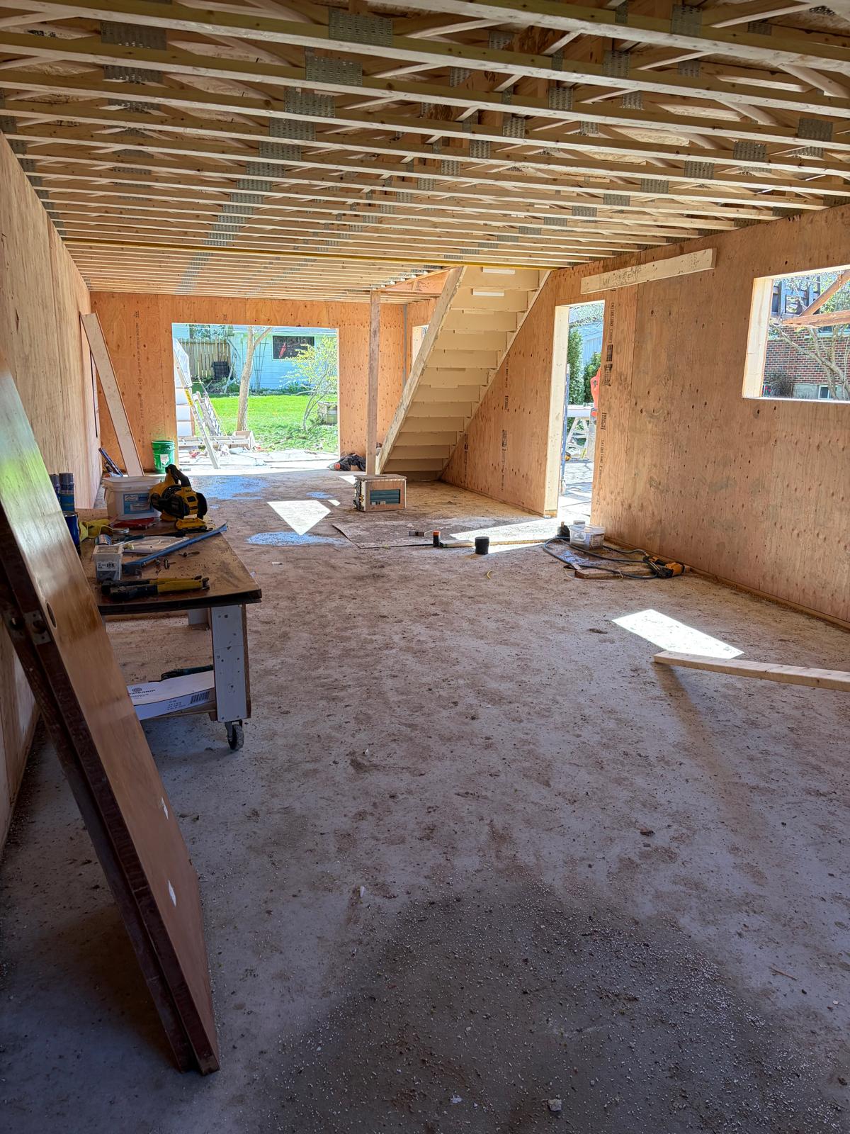 Wide angle interior view of SIP panel home showing open concept layout with staircase and work area