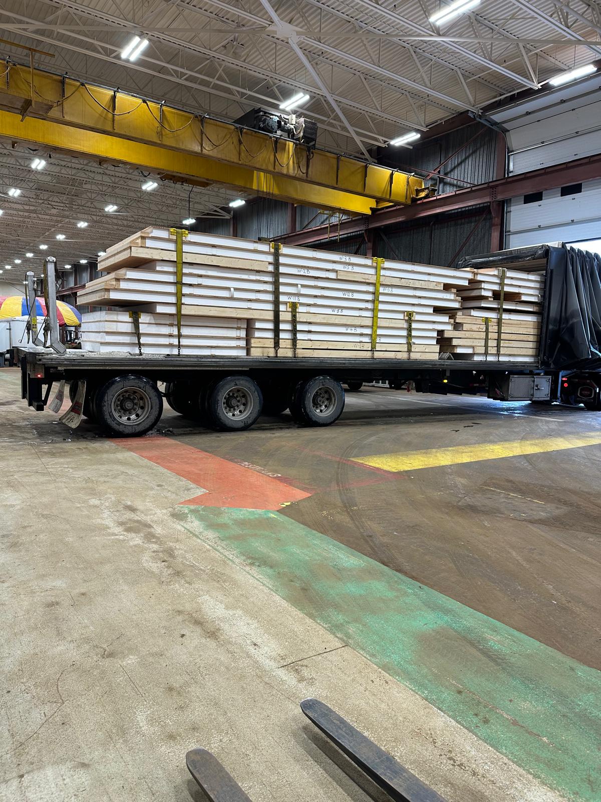 SIP panels stacked on flatbed truck inside warehouse ready for delivery across Canada